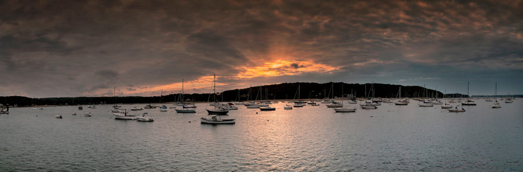 panorama photo of Northport harbor Long Island NY waterfront sunset with sailboats
